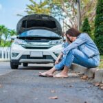 Asian,Woman,Sitting,Beside,Car,After,A,Car,Breakdown,On